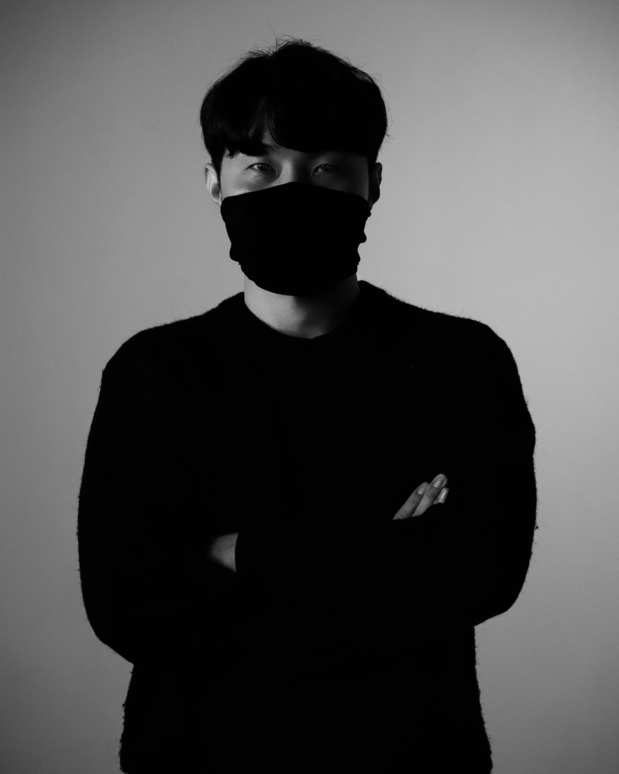 KUTH wearing a black mask, photographed in monochrome